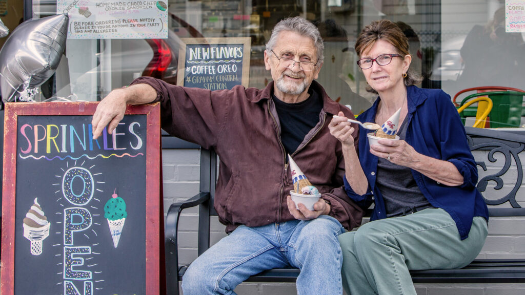 The owners of Sprinkles Ice Cream in Braintree enjoying a cone in front of their business.