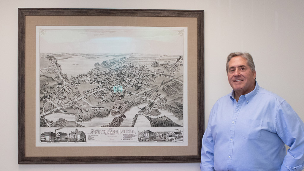 Richard MacAlesse standing near a vintage map of Braintree