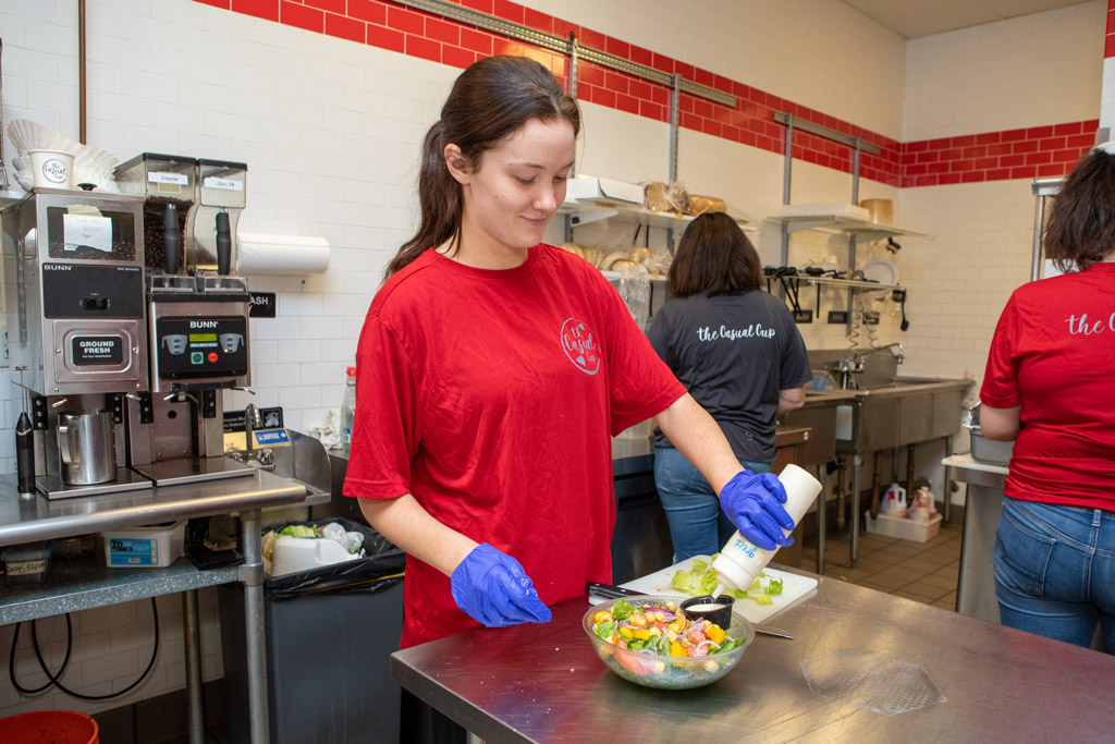 Employee preparing a salad at The Casual Cup